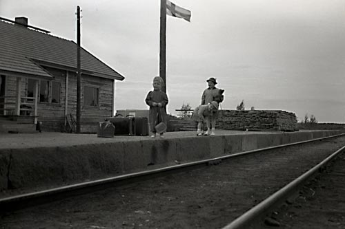 Fotografens son Jan Haglund och hans kusiner Mary-Ann "Pia" och Carita "Cita" Wilkman från Åggelby i väntan på tåget.