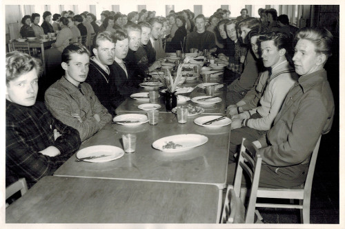 I matsalen läsåret 1956–57. Ordning och reda med gossar vid ett bord, flickor vid ett annat och besticken i ”färdig-med-ätandet-position”. Förstoring.
